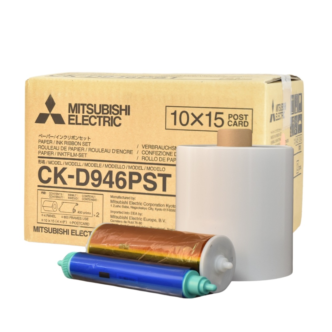Box of CK-D946PST dye sub media with paper roll and ribbon in front of it.