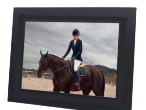 black photo mount with photo of person riding a horse