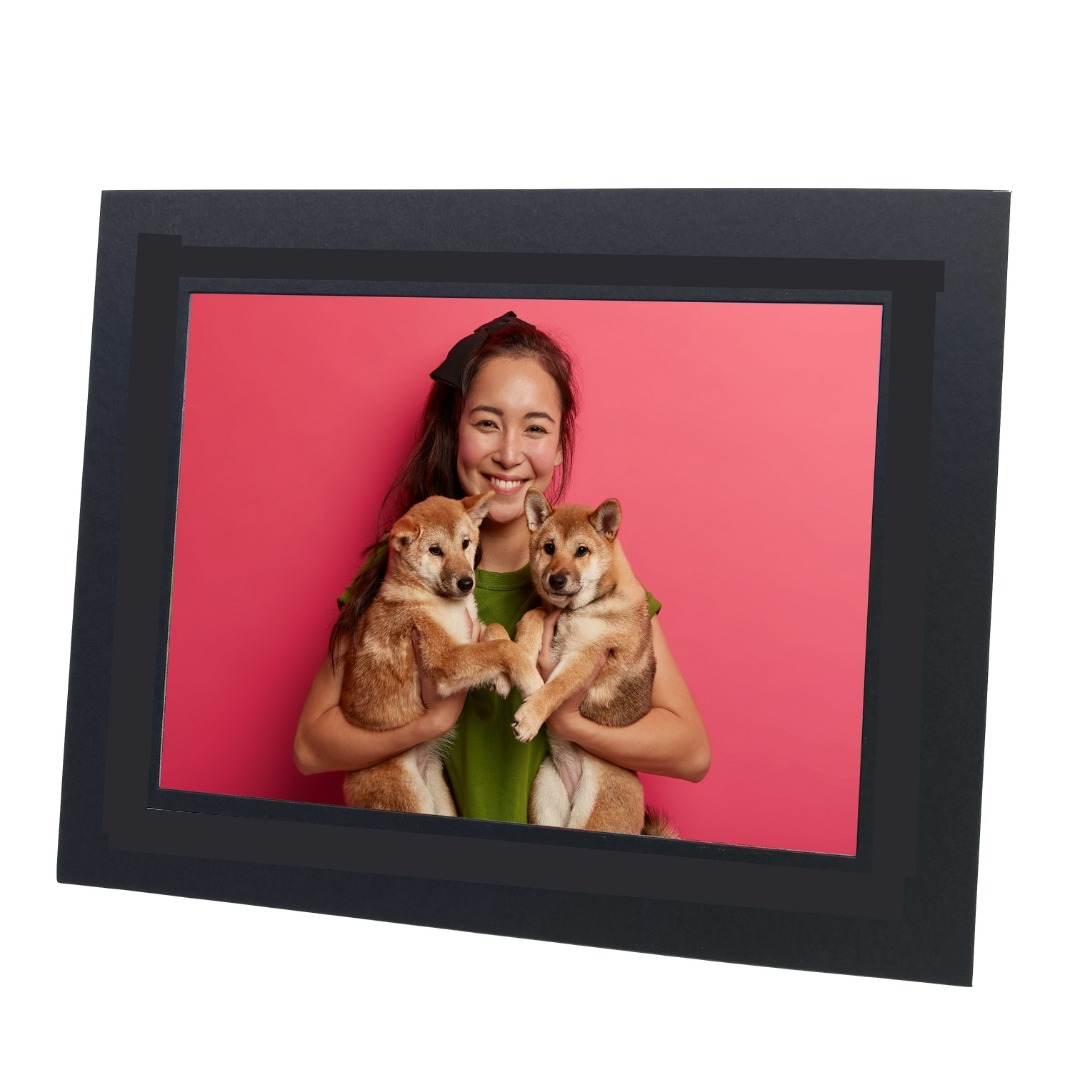 black photo mount with photo of woman holding two dogs