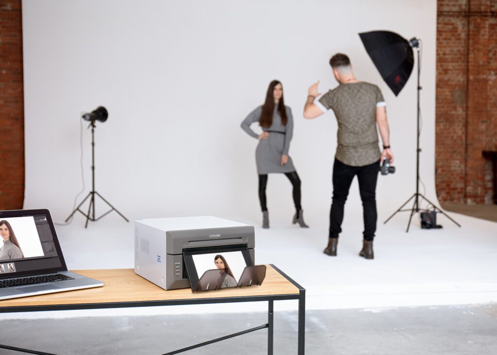 Photographer with a model, and a CX02W printer in the foreground.